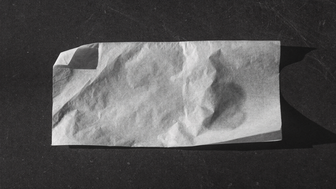 Fazzoletto di carta velina su superficie scura con una lieve traccia di sebo, il test per riconoscere il tipo di pelle