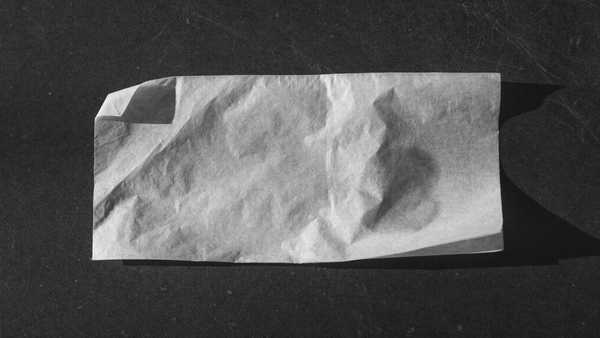 Fazzoletto di carta velina su superficie scura con una lieve traccia di sebo, il test per riconoscere il tipo di pelle