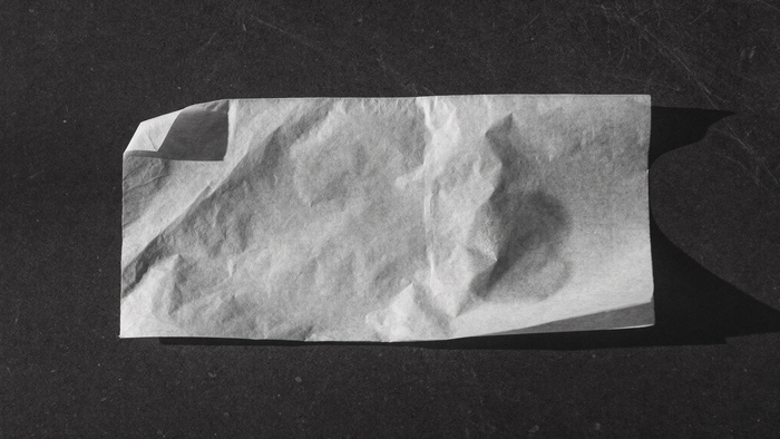 Fazzoletto di carta velina su superficie scura con una lieve traccia di sebo, il test per riconoscere il tipo di pelle