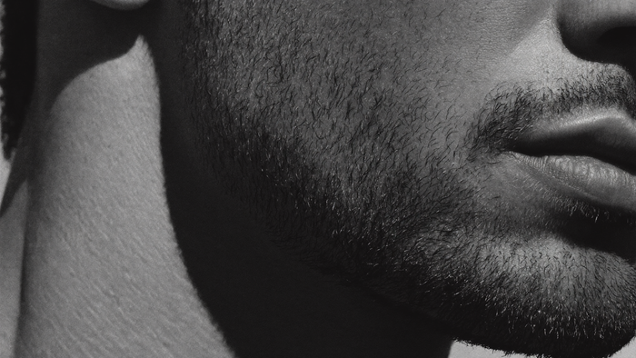 Texture macro monocromatica che evoca la pelle sotto la barba, tema skincare con la barba per uomo HBSKN
