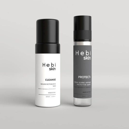 CLEANSE Mousse Detergente e PROTECT+ Crema SPF50+ Hebi Skin su sfondo neutro, packaging nero monocromatico