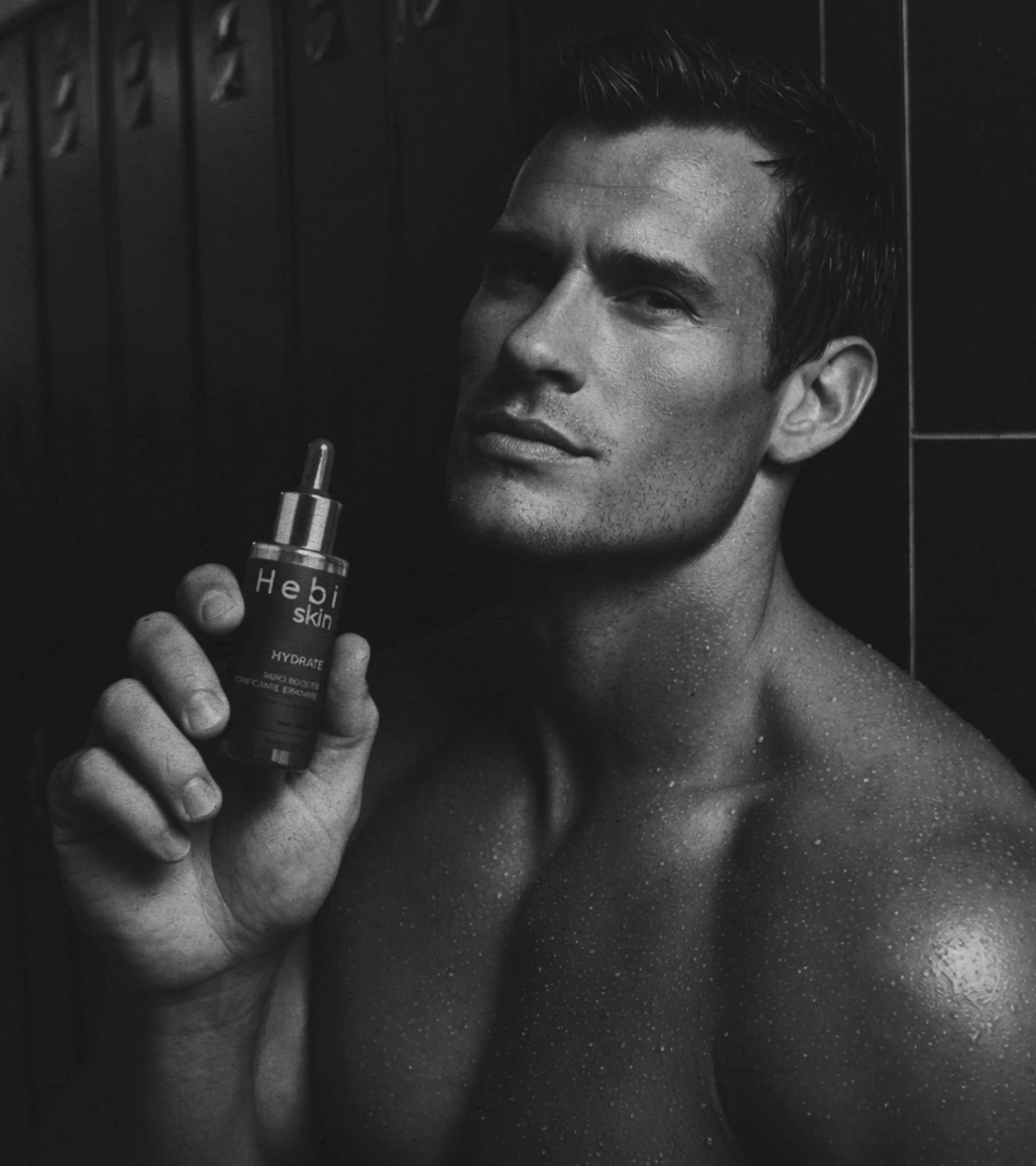 Atleta uomo post workout in palestra premium con HYDRATE in mano